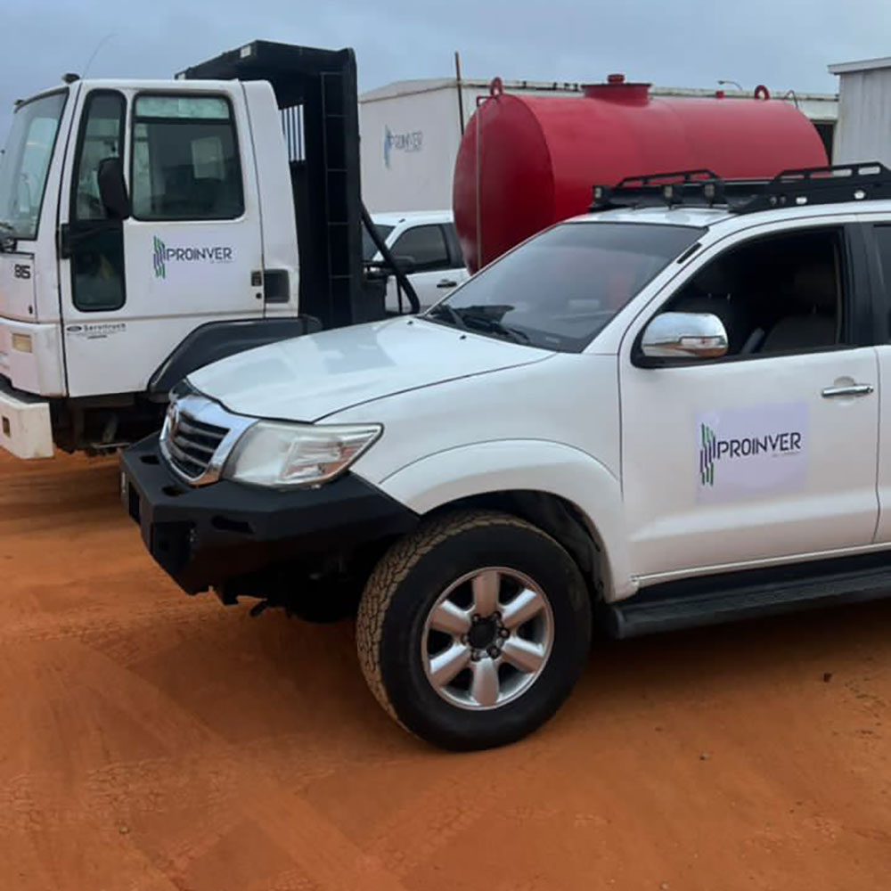 Camioneta y camión con la marca ProInver visibles en un área exterior.